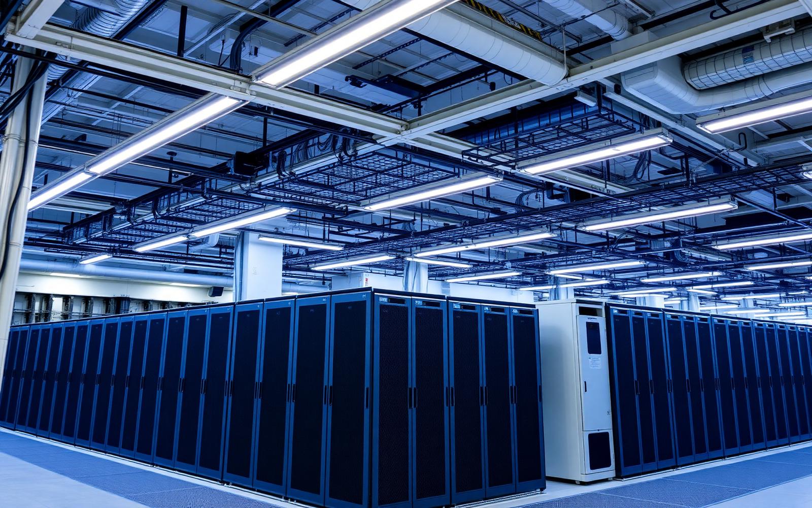 Rows of server racks with overhead cable trays and precision cooling in an enterprise server room