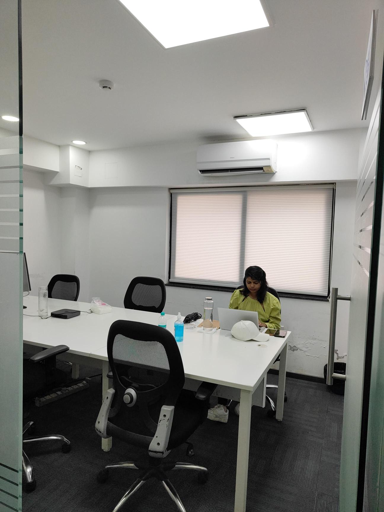 Team member working on a laptop in a Dev IT Serv meeting room