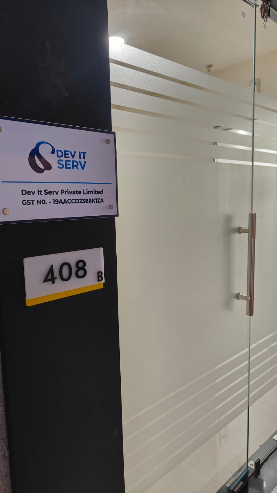 Entrance to the Dev IT Serv office with company signage on a glass doorway